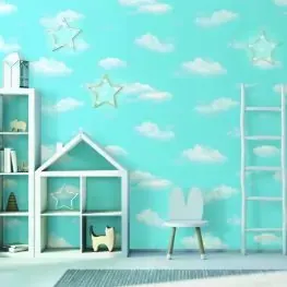 A bright room with turquoise walls featuring cloud patterns