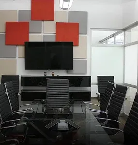 A modern conference room featuring a glass table and colorful soundproof panels on the walls