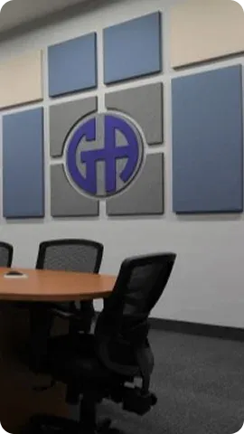 Modern meeting room featuring a circular logo on a textured wall, surrounded by gray and blue panels